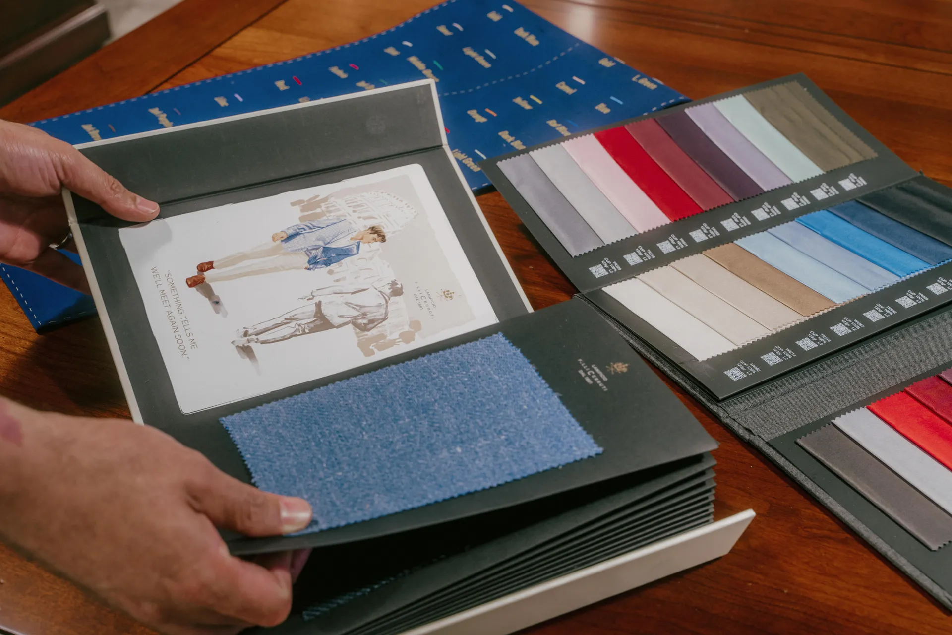 Open fabric books displaying color swatches and textile illustrations