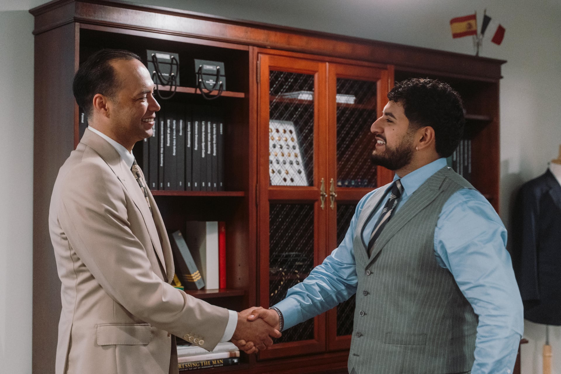 Fino client and master tailor shaking hands at the Los Gatos atelier after a wedding suit consultation