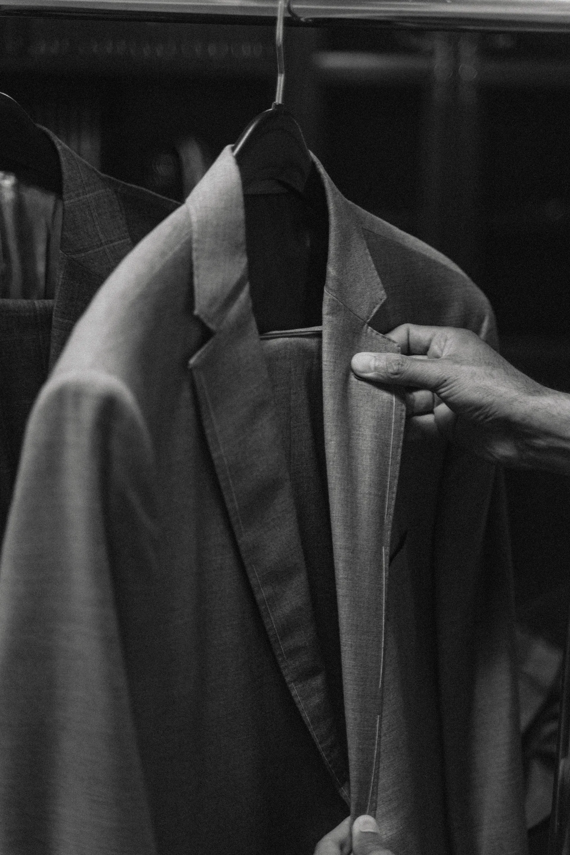 Finished bespoke suits hanging on a rack in the Fino studio