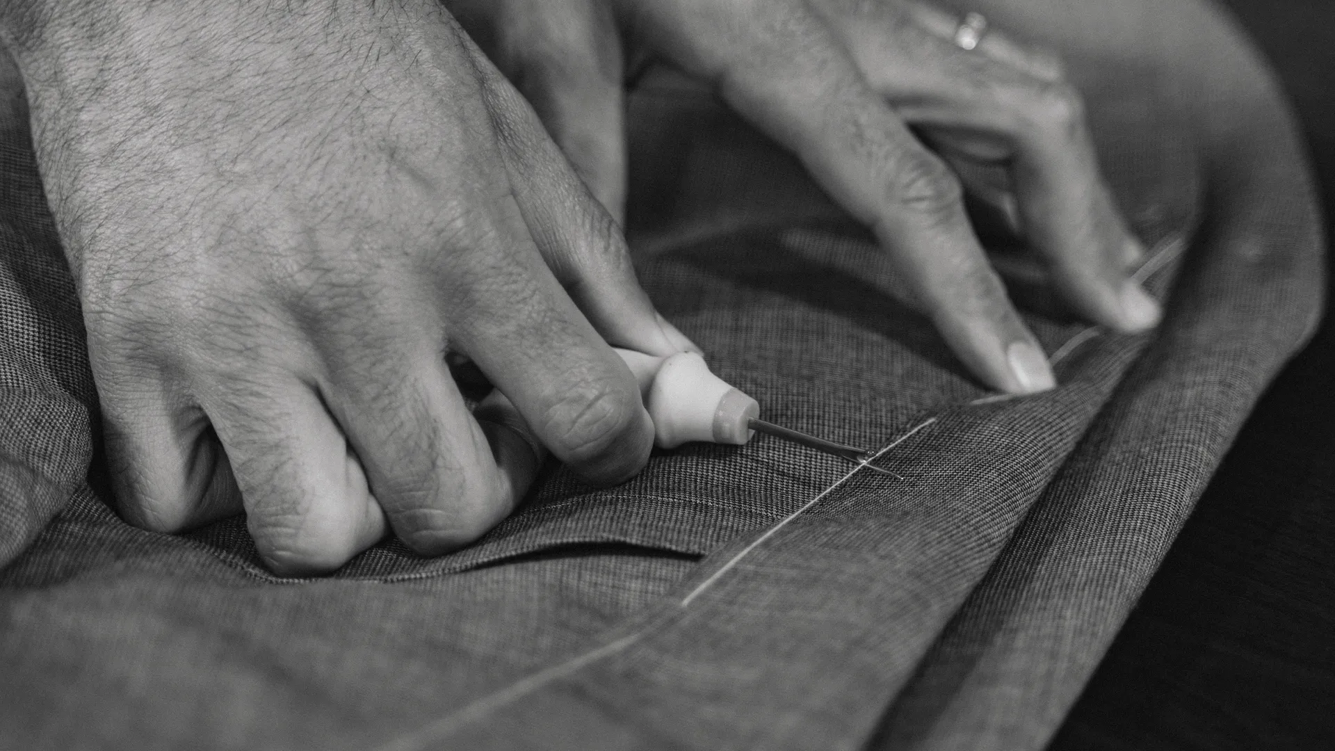 Master tailor hand-stitching suit details