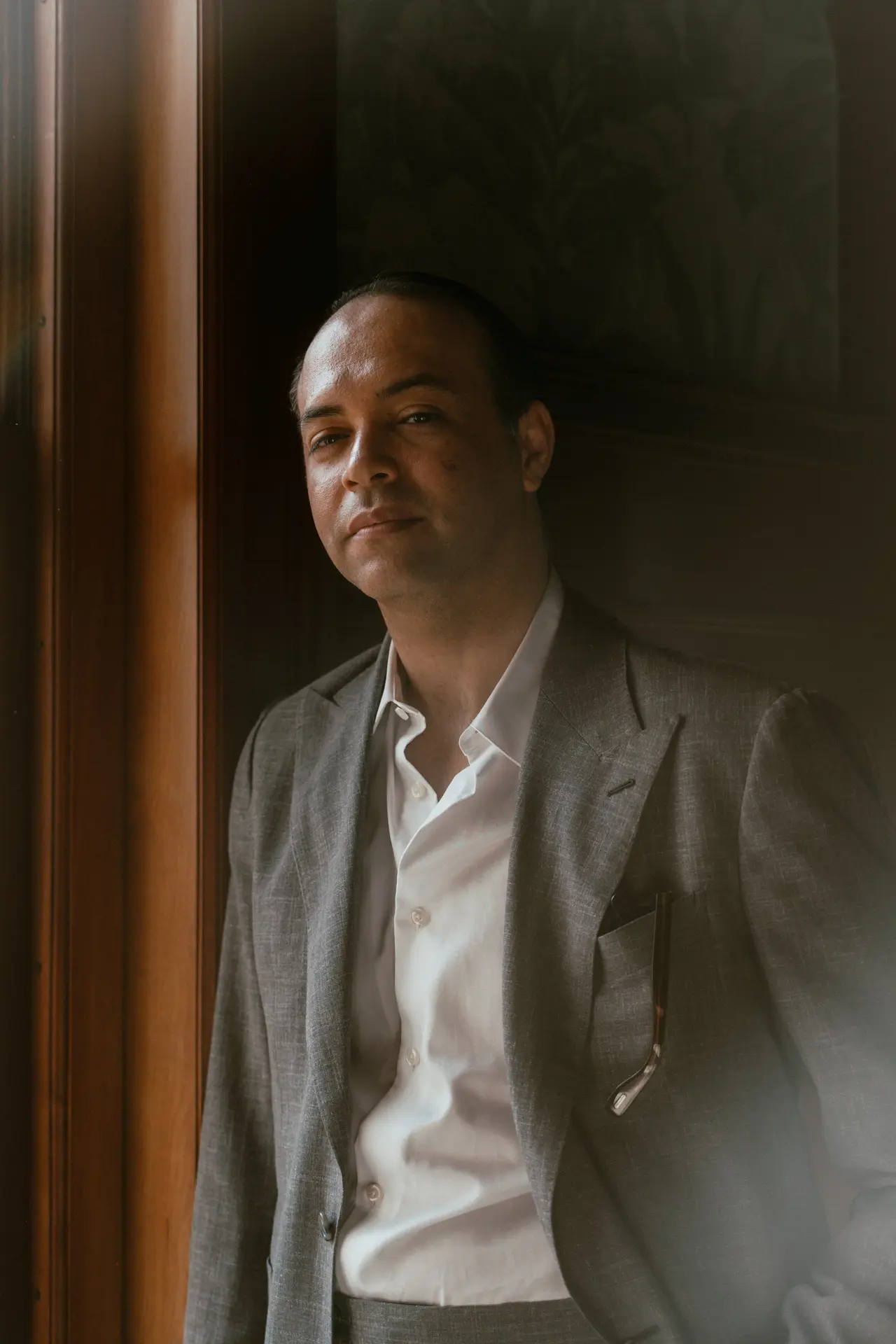 David Brenno in a grey jacket by a window
